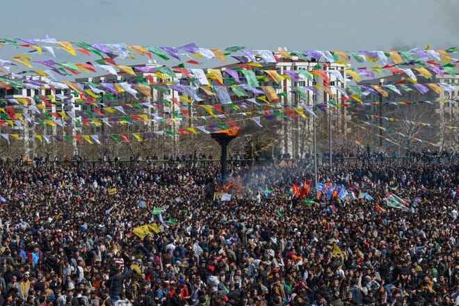 March 21, 2023: Turkish Kurds gather around a bonfire during a gathering of Turkish Kurds for Newroz (or Nowruz) celebrations marking the Persian New Year in Diyarbakir, southeastern Turkey. - Newroz (also known as Nawroz or Nowruz) is an ancient Persian festival, which is also celebrated by Kurdish people, marking the first day of spring, which falls on March 21.