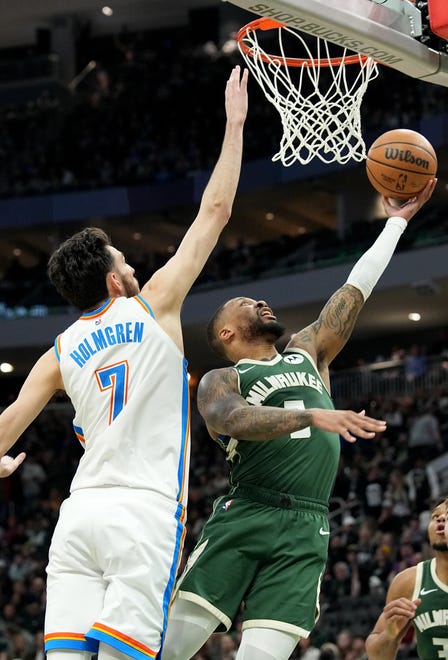 Milwaukee Bucks guard Damian Lillard (0) scores on Oklahoma City Thunder forward Chet Holmgren (7) during the first half of their game Sunday, March 24, 2024 at Fiserv Forum in Milwaukee, Wisconsin.