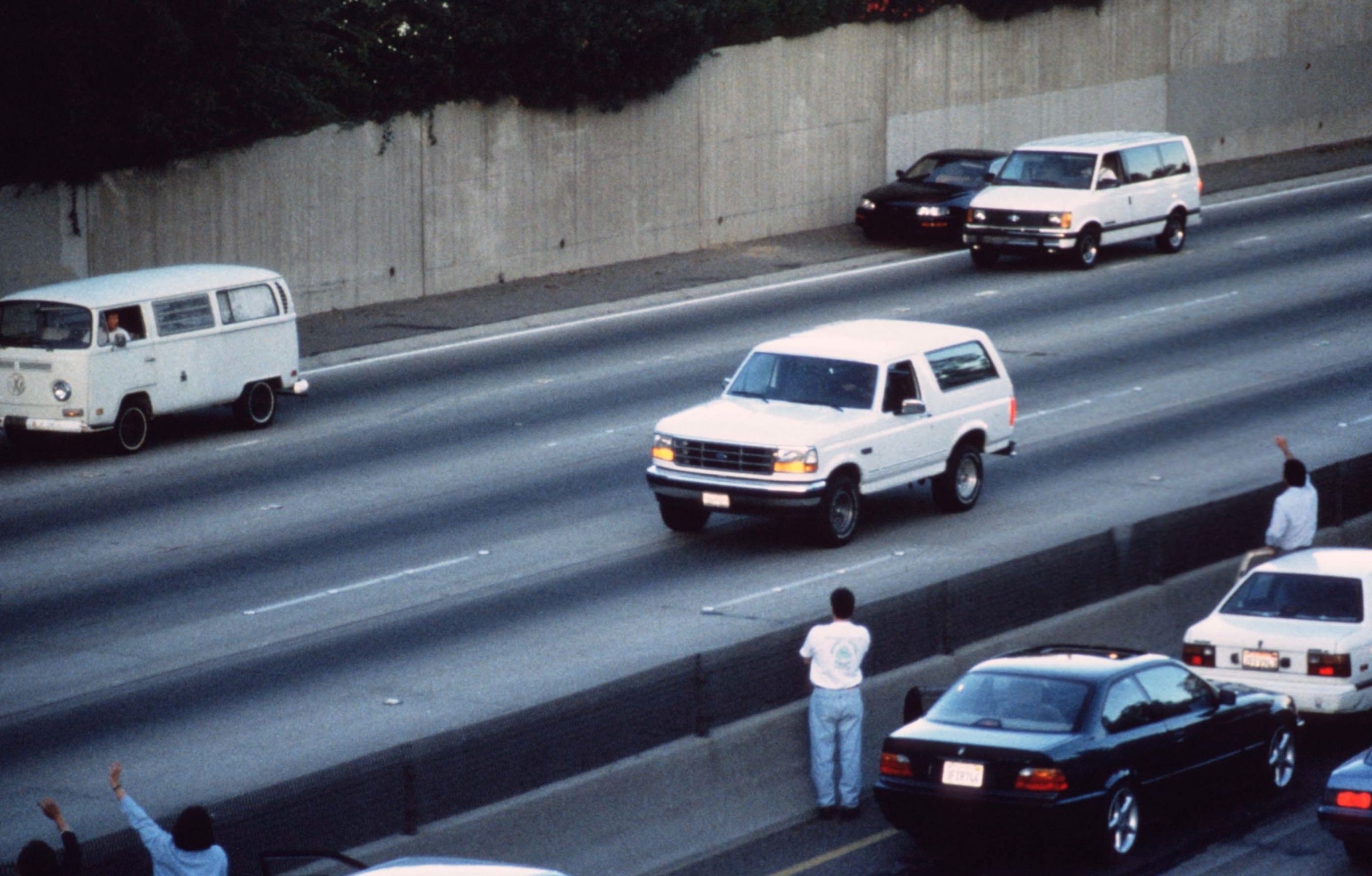 PHOTO: Motorists wave as police cars pursue the Ford Bronco (white, R) driven by Al Cowlings, carrying fugitive murder suspect O.J. Simpson, on a 90-minute slow-speed car chase June 17, 1994 on the 405 freeway in Los Angeles.