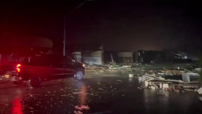 This image shows a car in front of debris that litters a street after a tornado in Sulphur, Oklahoma, on Saturday, April 27, 2024.