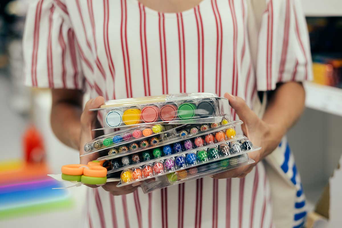 teacher holding art supplies