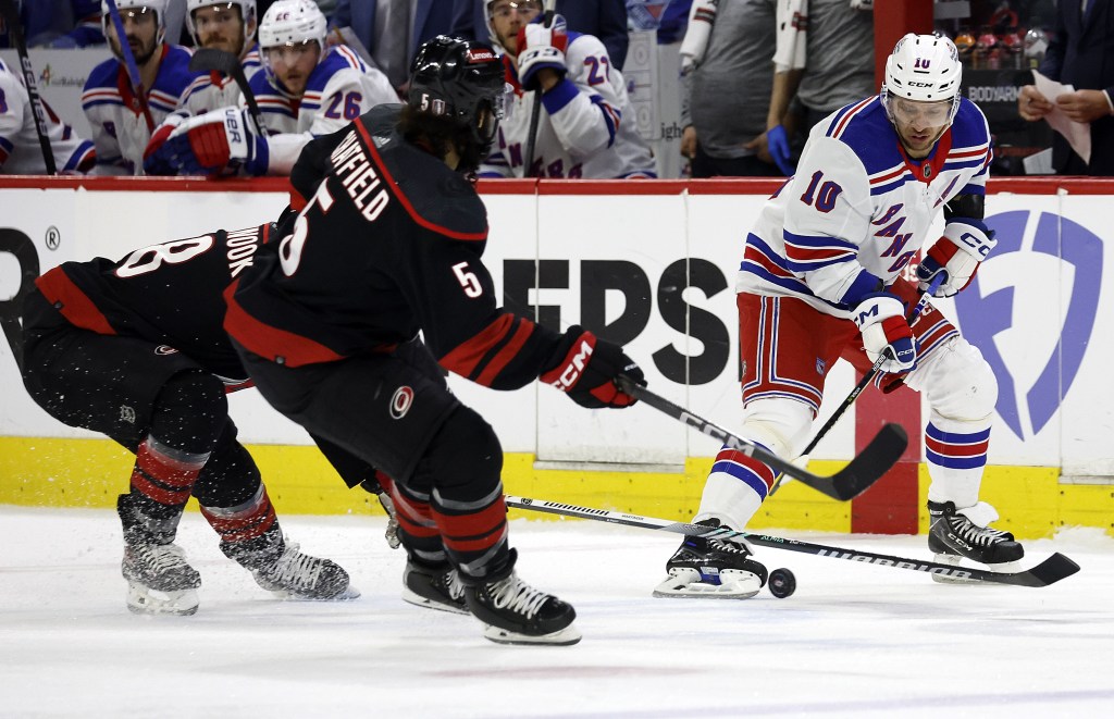 Artemi Panarin (10) loses control of the puck to Hurricanes' Jordan Martinook (48) and Jalen Chatfield (5) during the third period of the Rangers' Game 4 loss.