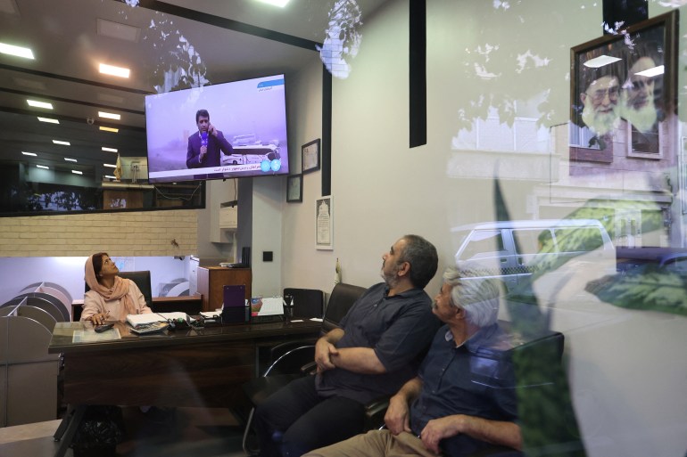 People watch TV amid news of the Iranian president's helicopter crash