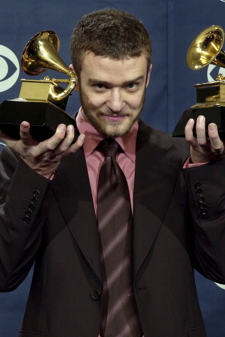 FILE - Justin Timberlake holds the awards he won for best male pop vocal performance and best pop vocal album at the 46th Annual Grammy Awards, Sunday, Feb. 8, 2004, in Los Angeles. (AP Photo/Reed Saxon, File)