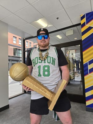 Jack McDougall shows up to the Celtics parade with a replica trophy.