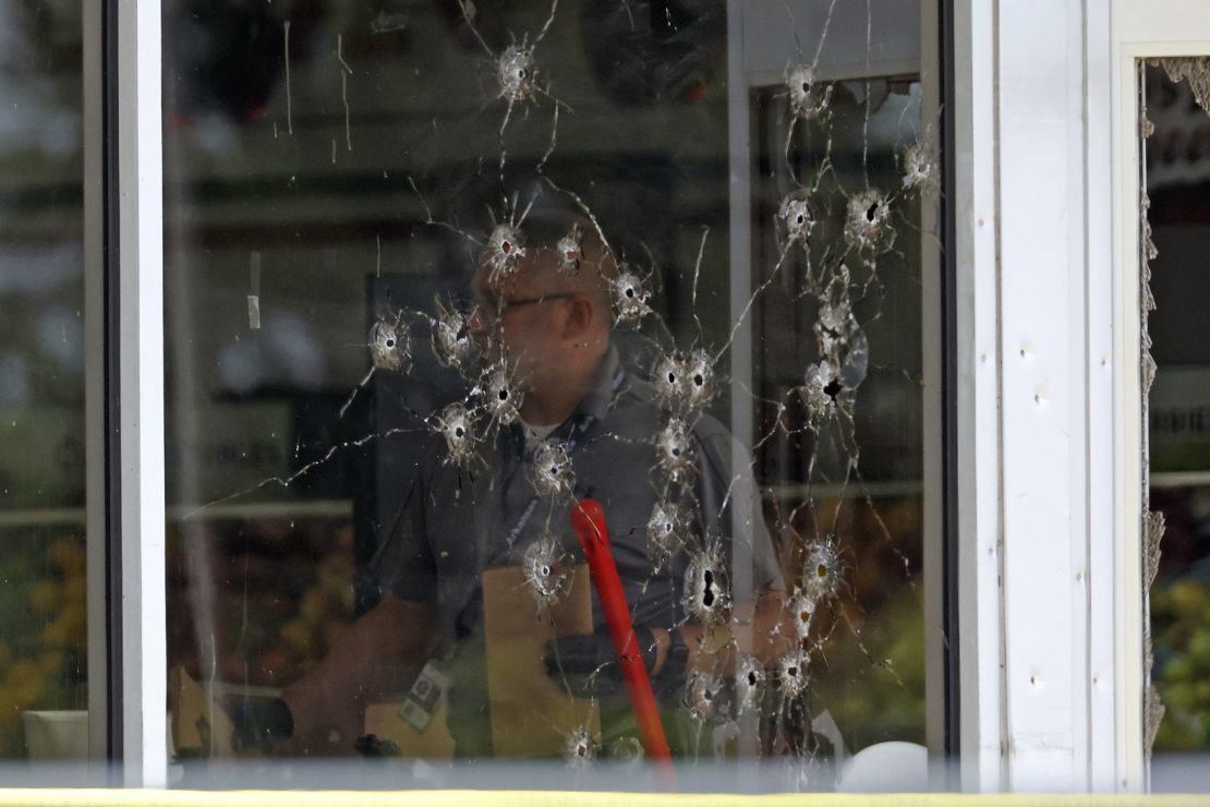 Damage can be seen to a front window as a law enforcement officer investigates on Friday.