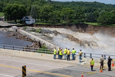 People look down at a flowing river