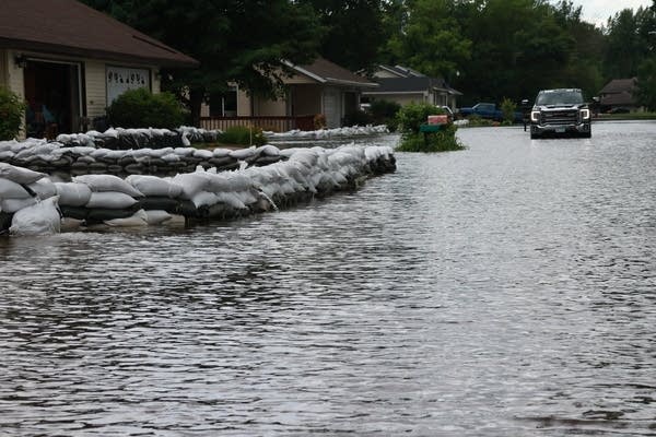 sandbags & flooded road with pickup truck