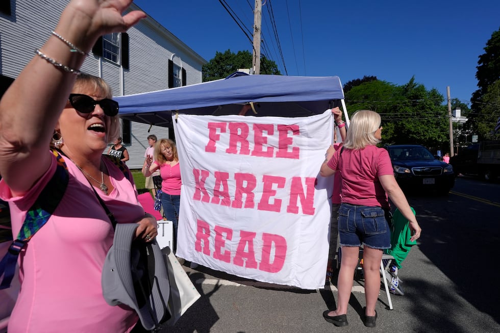 Eva Jenkins, of Bourne, Mass., left, a supporter of Karen Read, waves to passing cars as other...