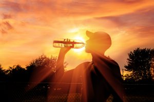 Man drinking water in the sun.