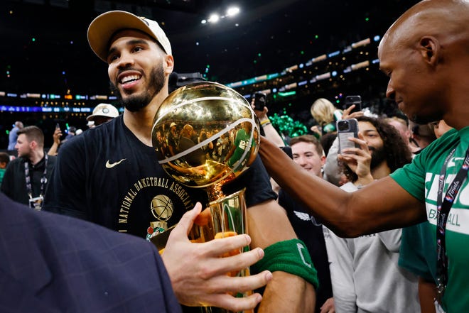 Jun 17, 2024; Boston, Massachusetts, USA; Boston Celtics forward Jayson Tatum (0) is greeted by Ray Allen as he walks off the court with the trophy as he celebrates winning the 2024 NBA Finals against the Dallas Mavericks at TD Garden. Mandatory Credit: Peter Casey-USA TODAY Sports