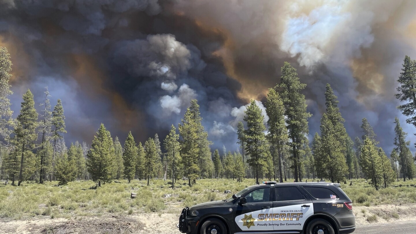 Wind-driven wildfire spreads outside a central Oregon community and prompts evacuations