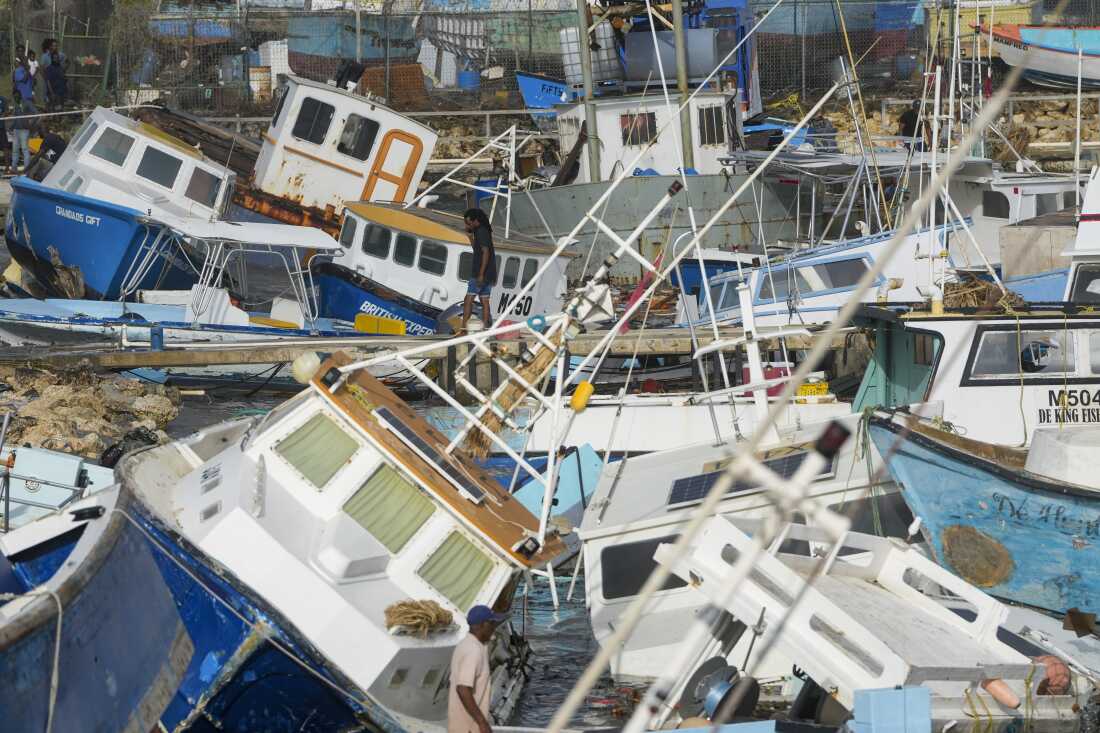 A fisherman looks at damaged fishing vessels.