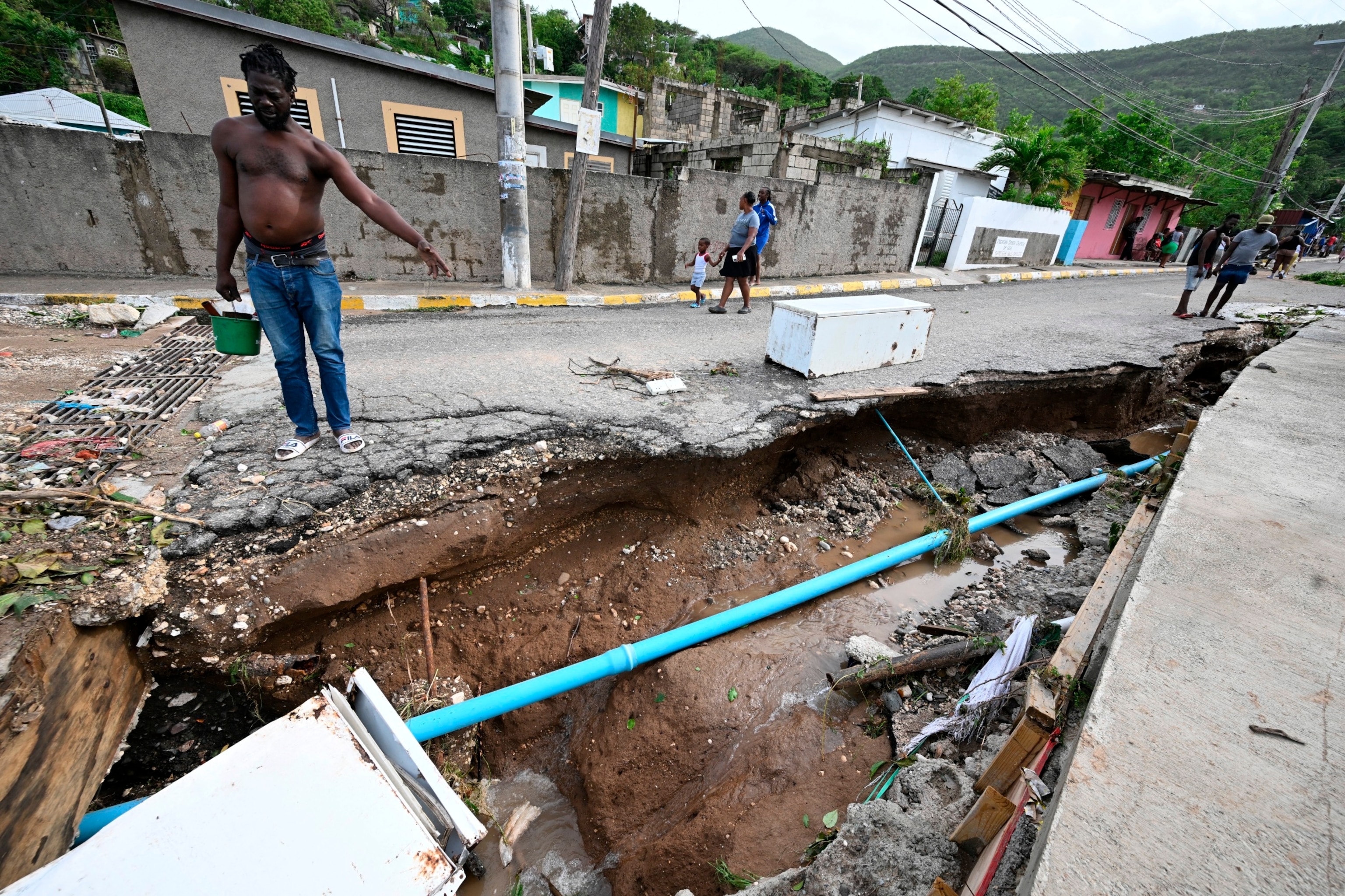 PHOTO: Residents look at a damaged drain in Shooters Hill, Jamaica, in the aftermath of Hurricane Beryl on July 4,2024.