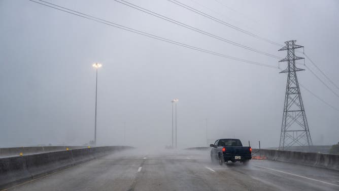 A vehicle drives through heavy rain on a highway during Hurricane Beryl on July 08, 2024 in Houston, Texas.