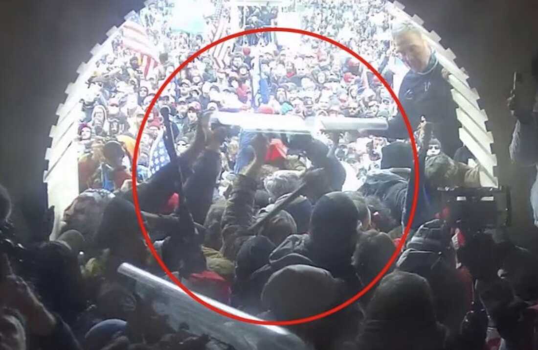 Federal investigators said Jay Johnston, seen here circled in red holding a stolen police shield over his head, helped a crowd push police down a tunnel at the Capitol building on Jan. 6, 2021.