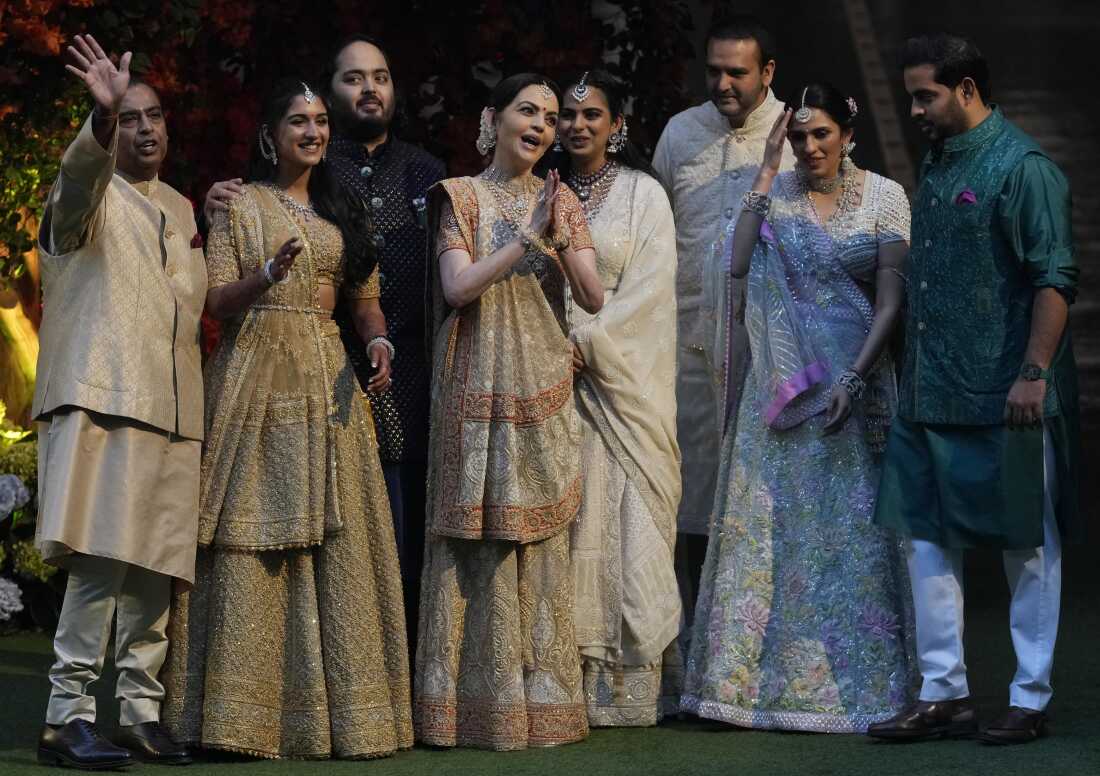 Reliance Industries Chairman Mukesh Ambani (left) waves to photographers as he poses with his family members on the occasion of engagement of his son Anant Ambani (third from left), with Radhika Merchant (second from left) during a ceremony in Mumbai, on Jan. 19, 2023. 