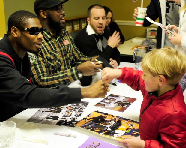 Matthew Wilson of Pylesville, right, gives Baltimore Ravens player Jacoby...