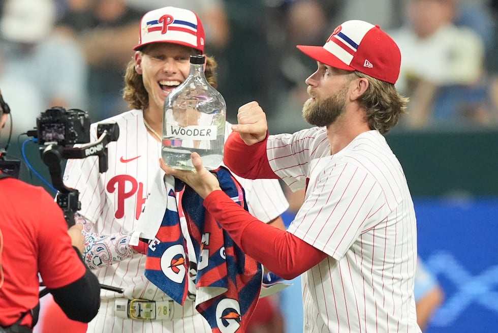 National League's Alec Bohm, of the Philadelphia Phillies, center, jokes with teammate Bryce...