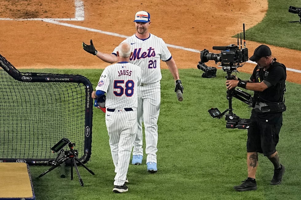 Pete Alonso, center, of the New York Mets, greets Dave Jauss, left, former coach, after...