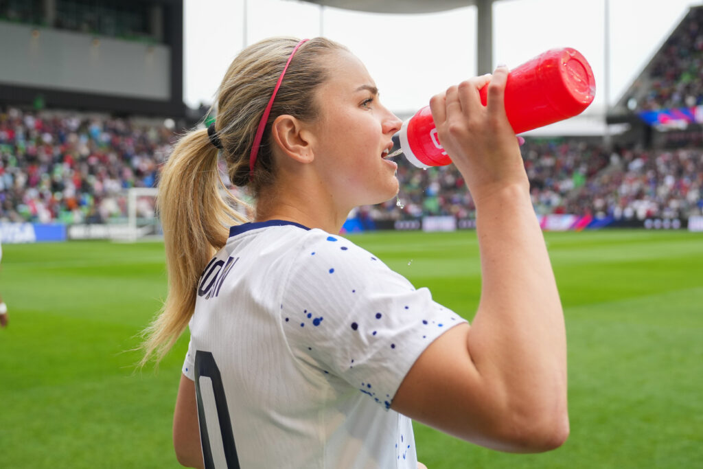 Lindsay Horan drinks water before the USWNT's match against Ireland in April 2023.