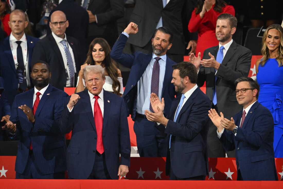 US former President and 2024 Republican presidential candidate Donald Trump (bottom, 2nd L) cheers alongside (from bottom L) US Representative of Florida Byron Donalds, US Senator from Ohio and 2024 Republican vice-president candidate J. D. Vance, and House Speaker Mike Johnson, (from top R) Co-chair of the Republican National Committee Lara Trump, son Eric Trump, son Donald Trump Jr., and US TV news personality Kimberly Guilfoyle as he arrives during the first day of the 2024 Republican National Convention at the Fiserv Forum in Milwaukee, Wisconsin, July 15, 2024. 