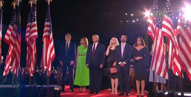 President Donald Trump stands with family members listening to a singer on the White House balcony after speaking during the Republican National Convention at the White House in Washington, D.C.