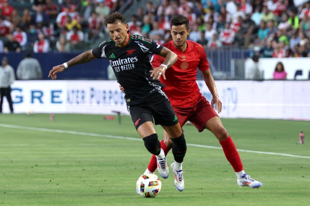 Arsenal defender Ben White, left, controls the ball in front...