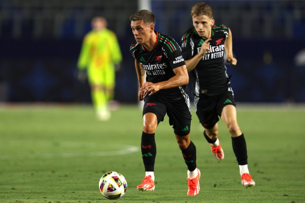 Arsenal midfielder Leandro Trossard, front, moves the ball up the...