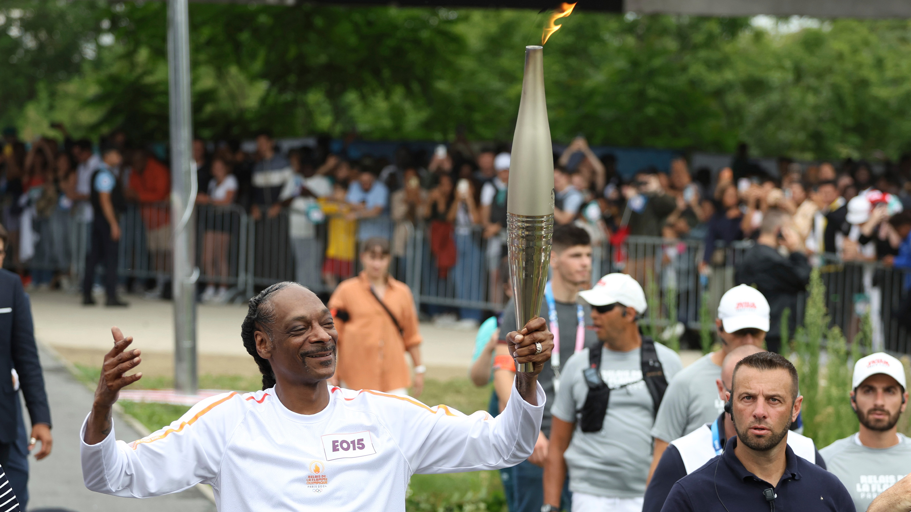 Snoop Dogg carries the Olympic torch at the 2024 Summer Olympics, Friday, July 26, 2024, in Saint-Denis, outside Paris, France.