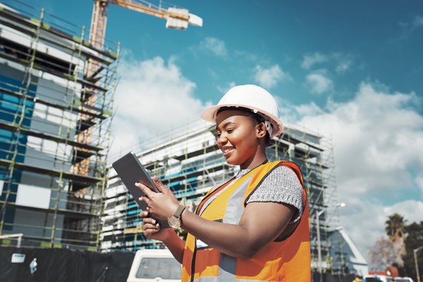 Smiling construction worker looking at tablet.