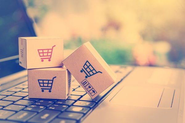 Small boxes with shopping cart logos sitting on laptop keyboard.