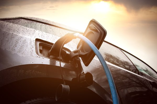 An electric vehicle hooked up to a charger.