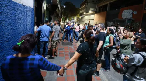 Getty  A group of people hold hands in protest to be let in to count the votes during the presidential election on July 28, 2024 in Caracas, Venezuela. 