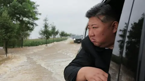 Rodong Sinmun North Korea leader Kim Jong Un travels through a flooded area.