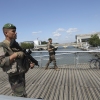 Soldiers patrol on a footbridge over the Seine river, Wednesday, July 17, 2024 in Paris. France's armed forces held a demonstration of the security measures planned on the River Seine, both in and out of the water, to make it safe for athletes and spectators during the opening ceremony of the Paris Olympics. Organizers have planned a parade of about 10,000 athletes through the heart of the French capital on boats on the Seine along a 6-kilometer (3.7-mile) route at sunset on July 26. (AP Photo/Aurelien Morissard)