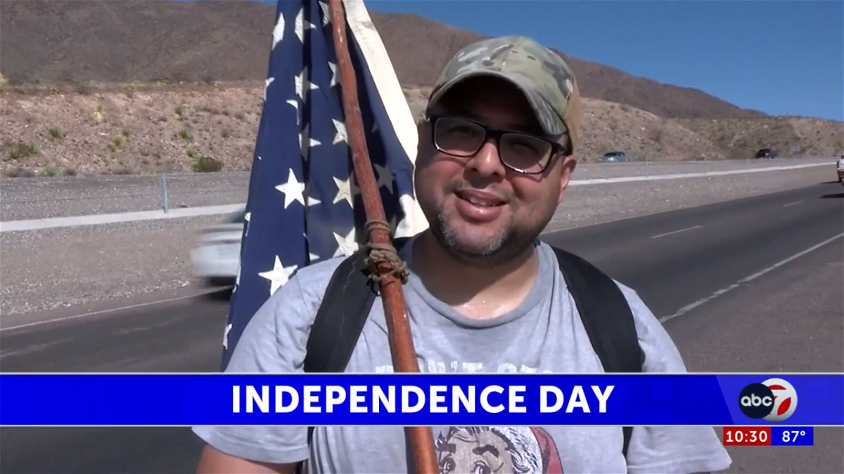 Man walks up Transmountain carrying American flag in honor of Independence Day