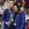 Gold medalist, Torri Huske, right stands with silver medalist Gretchen Walsh, both of whom are on Team USA, after the women's 100-meter butterfly final at the Paris Olympics on Sunday. 