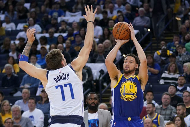 March 23, 2019; Oakland, CA, USA; Golden State Warriors guard Klay Thompson (11) shoots the basketball against Dallas Mavericks forward Luka Doncic (77) during the third quarter at Oracle Arena. Mandatory Credit: Kyle Terada-USA TODAY Sports