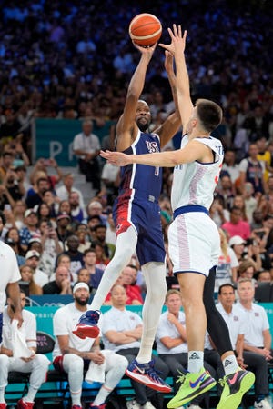 Jul 28, 2024; Villeneuve-d'Ascq, France; United States guard Kevin Durant (7) shoots against Serbia centre Filip Petrusev (3) in the second quarter during the Paris 2024 Olympic Summer Games at Stade Pierre-Mauroy. Mandatory Credit: John David Mercer-USA TODAY Sports