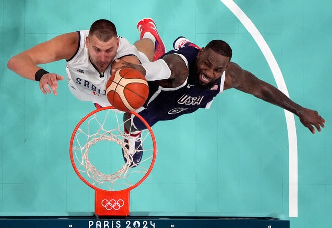 Jul 28, 2024; Villeneuve-d'Ascq, France; Serbia power forward Nikola Jokic (15) and United States guard Lebron James (6) jump for a rebound in the fourth quarter during the Paris 2024 Olympic Summer Games at Stade Pierre-Mauroy. Mandatory Credit: John David Mercer-USA TODAY Sports