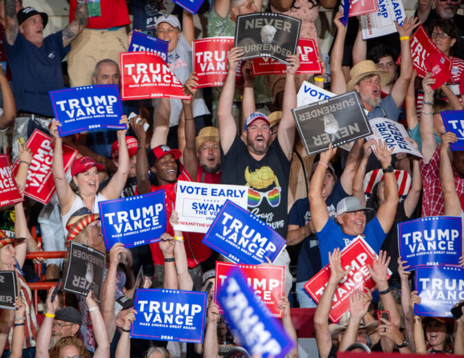 Attendees hold up campaign signs during a rally for Donald Trump in the New Holland Arena at the Pennsylvania Farm Show complex in Harrisburg Wednesday, July 31, 2024.