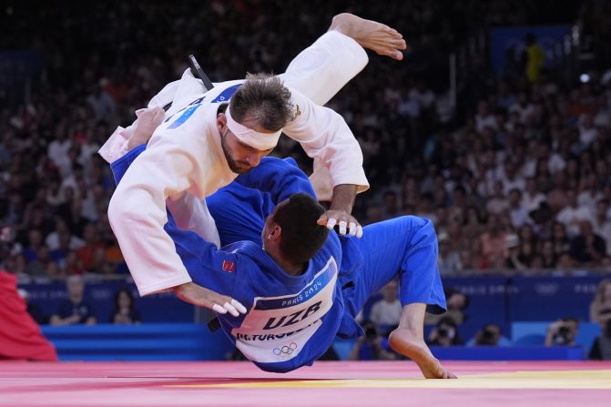 Azerbaijan's Zelym Kotsoiev, top, and Uzbekistan's Muzaffarbek Turoboyev compete in a judo semifinal on August 1. Kotsoiev would go on to win the gold. Toroboyev won the bronze.