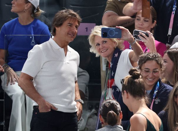 Actor Tom Cruise takes a photo with a fan during the women's gymnastics qualification round on July 28. Other celebrities watching included Snoop Dogg and Ariana Grande.