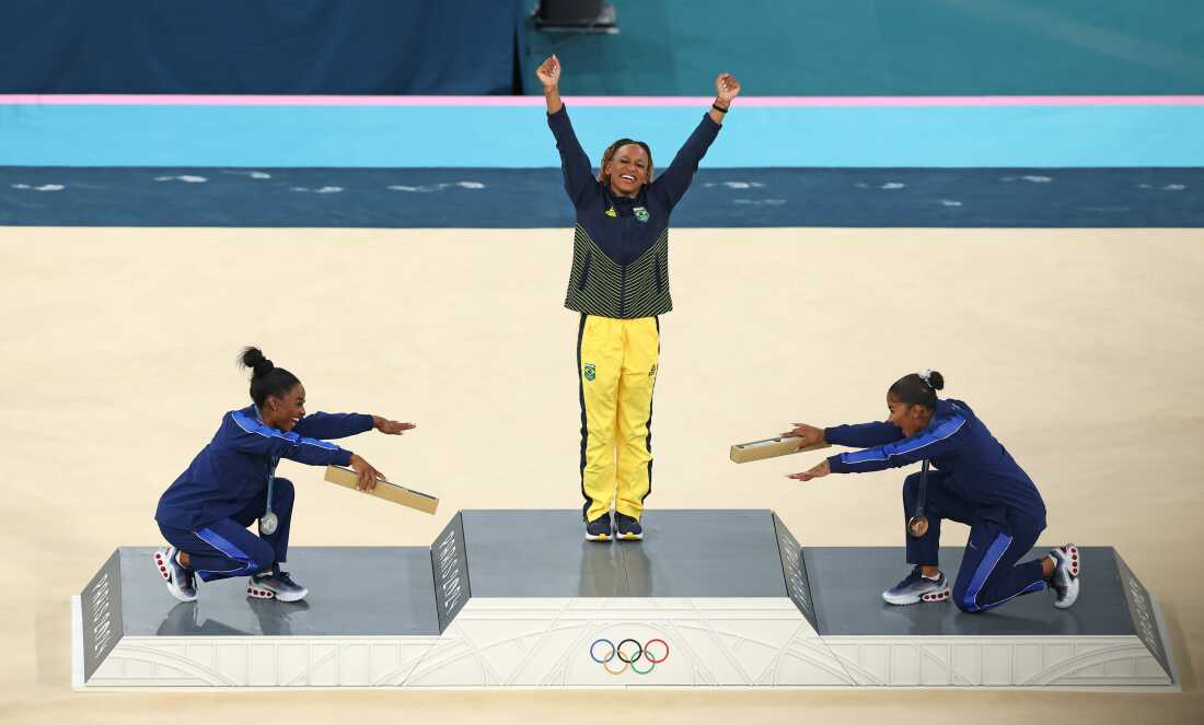 Gold medalist Rebeca Andrade (C) of Brazil along with silver medalist Simone Biles (L) and bronze medalist Jordan Chiles (R) of the U.S. celebrate on the podium at the women's gymnastics floor exercise medal ceremony on Monday at Bercy Arena in Paris.