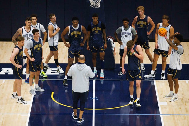 Notre Dame men's basketball players listen to head coach Micah Shrewsberry, in the gray hoodie, talk through a drill during an open practice at Rolfs Athletics Hall on Thursday, July 18, 2024, in South Bend.