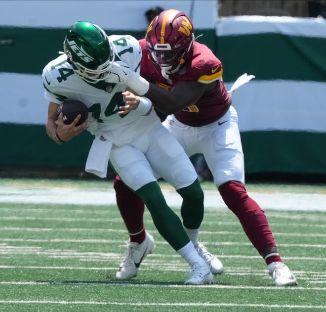 East Rutherford, NJ -- August 10, 2024 -- Jets quarterback Andrew Peasley is sacked by KJ Henry of the Commanders in the first half as the Washington Commanders came to MetLife Stadium to play the New York Jets in the first press season game of the 2024 season.