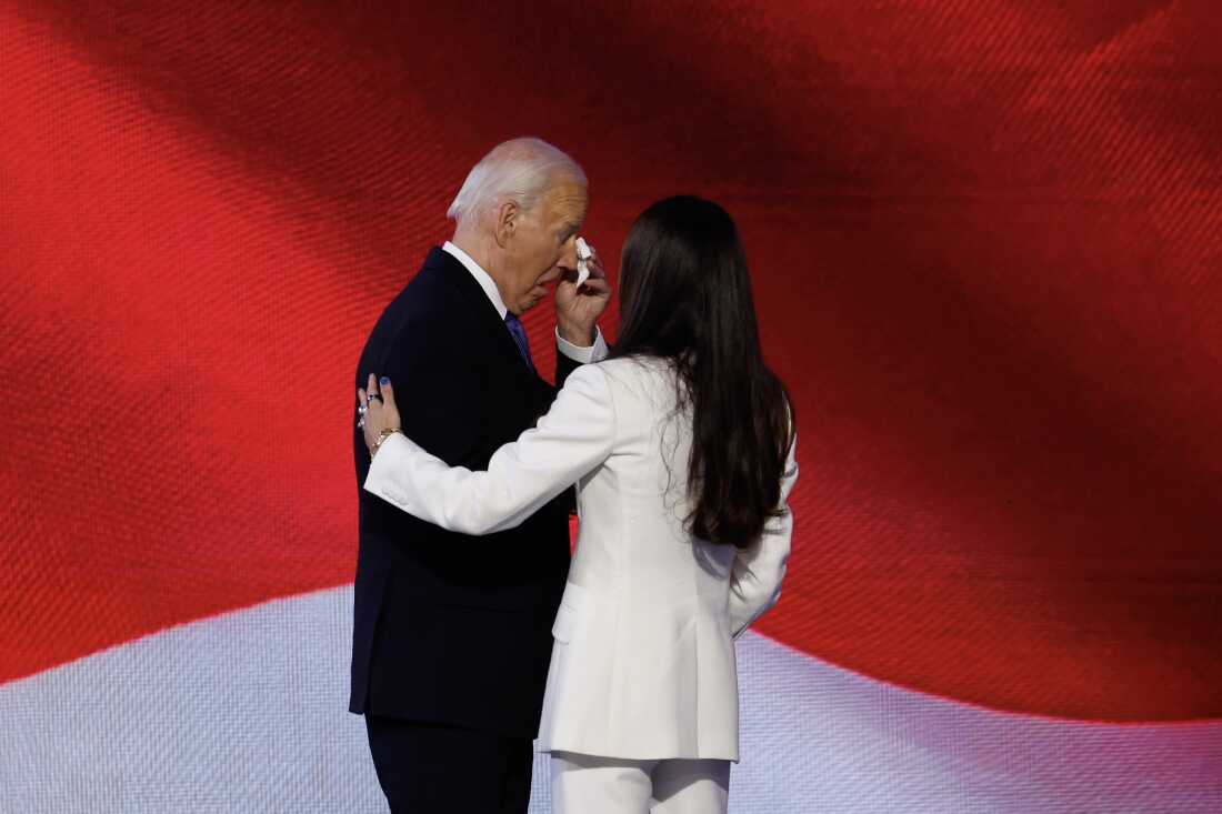 Joe Biden wipes away a tear on stage.