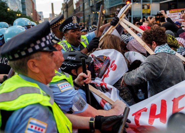 Activists scuffle with Chicago police outside the Israeli Consulate while...