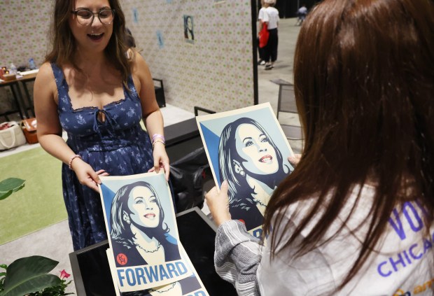 Sabrina Collins, left, hands out free posters of Vice President...